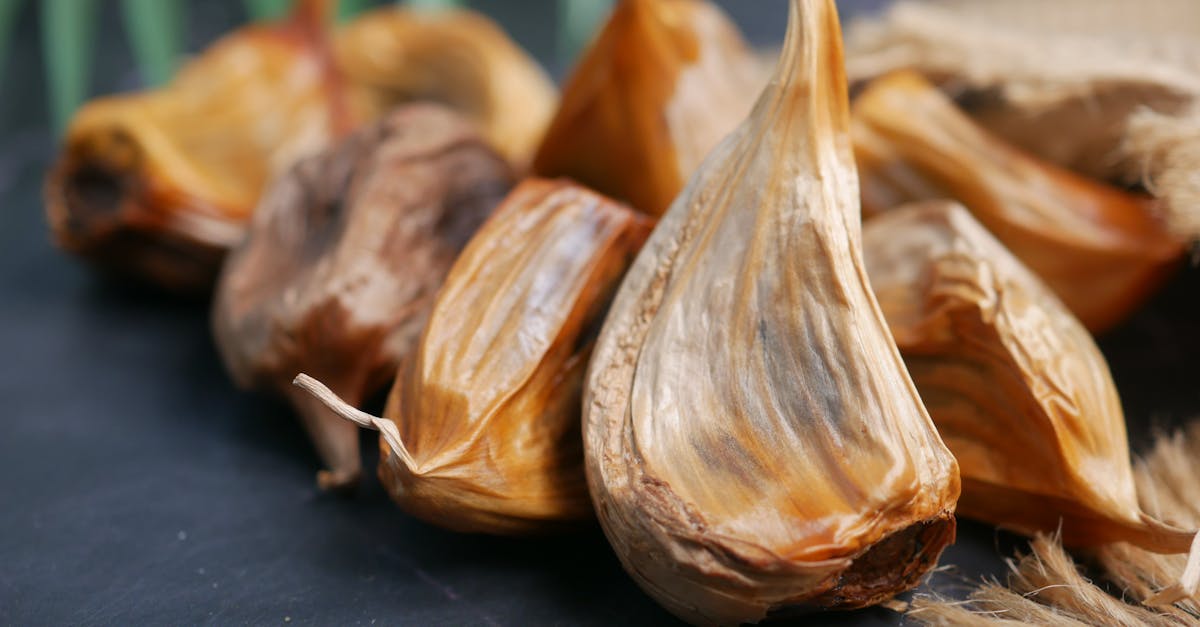 Detailed close-up of aged black garlic cloves on a dark background
