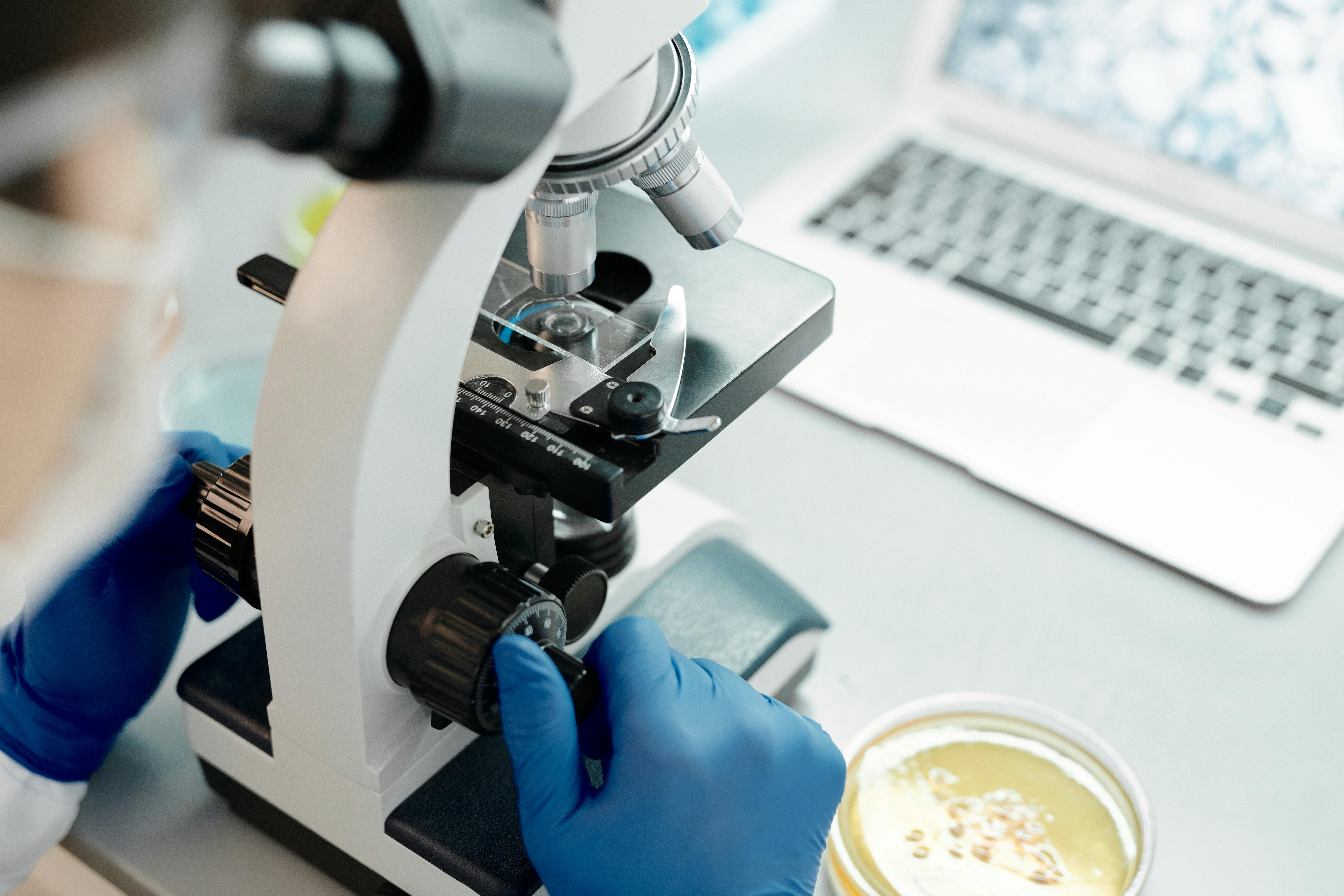 Researcher analyzing biological samples under a microscope in a laboratory